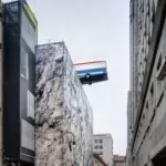 Bus in bilico su un palazzo a Torino: è un’installazione per Artissima